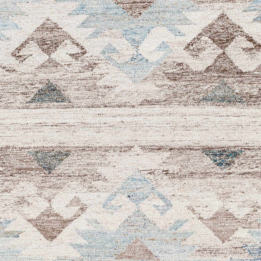 Close-up of Duyen Area Rug showing hand-woven texture and Scandinavian-Southwestern geometric pattern in blue, brown, and white. Swatch