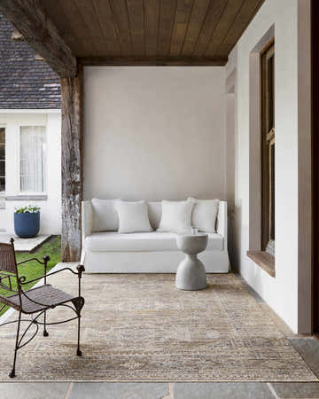 Covered patio with white sofa and Margaret Sage Washable Rug. Farmhouse style with neutral colors. Becki Owens x Livabliss rug. Roomscene-Rectangle