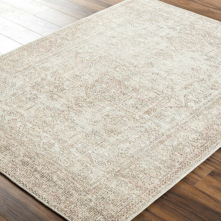Close-up of Margot Medallion Dusty Coral rug. Beige, brown, and coral tones in a traditional, distressed medallion pattern. Corner