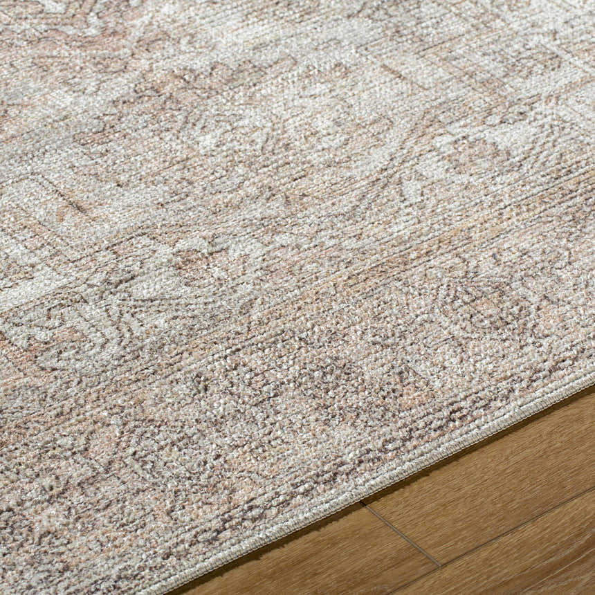 Close-up of the Margot Medallion Dusty Coral rug, a traditional design in beige, bone, and dusty coral on wood flooring. Texture