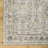 Close-up of the Jeven Blue Area Rug showing traditional beige and beachhouse blue floral pattern and soft polyester texture. Corner