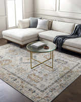 Living room scene with a Kamau Cream & Blue Area Rug, white sectional sofa, glass coffee table, and dark wood floors. Roomscene-Rectangle