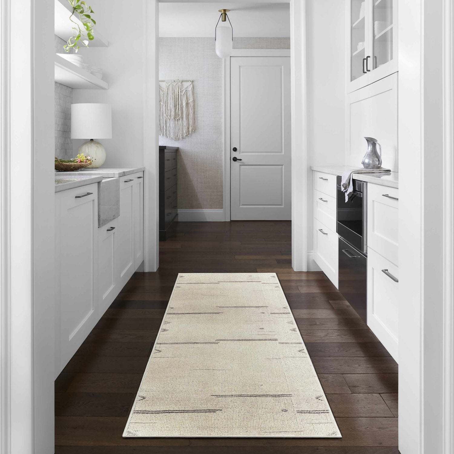 Farmhouse style mudroom with white cabinets and Rivin Beige Rug - Becki Owens x Livabliss on dark wood floors. Roomscene-Runner