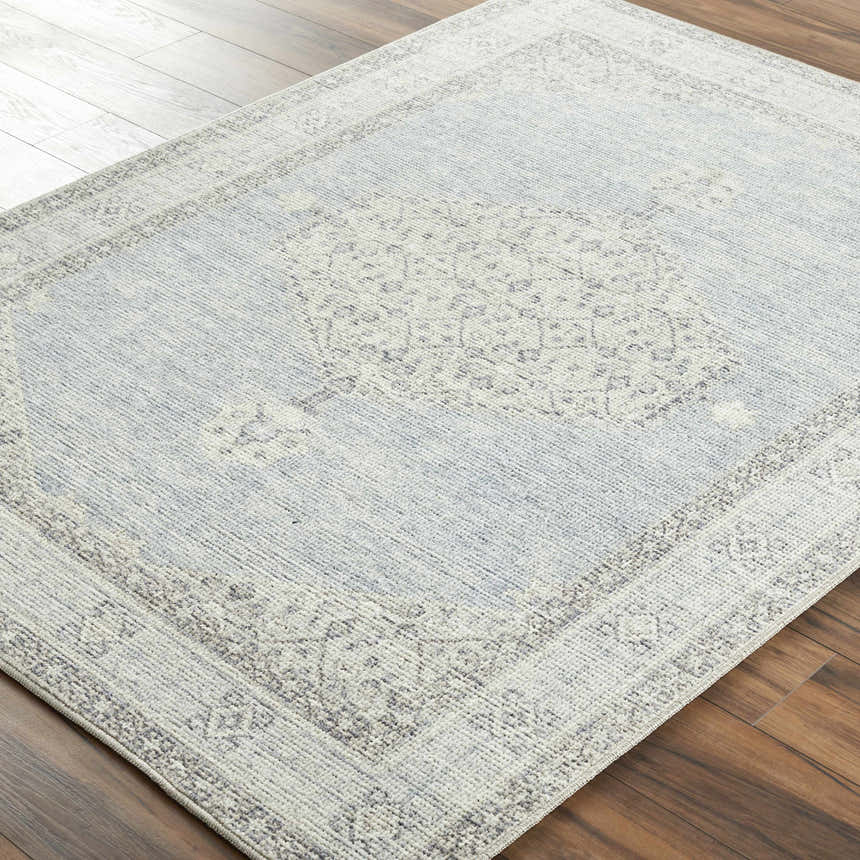 Close-up of Lila Medallion Denim Area Rug. Farmhouse style rug with charcoal, gray, and nutmeg medallion pattern. Corner