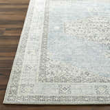 Close-up of the Lila Medallion Denim Area Rug. Farmhouse style rug in charcoal, gray, and denim on a dark wood floor. Front