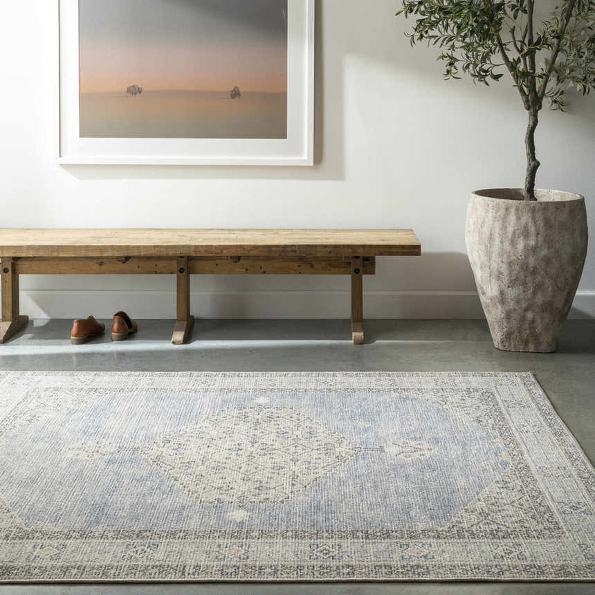 Entryway with wood bench, potted tree, and Lila Medallion Denim Area Rug in charcoal, dark gray, and light gray. Roomscene-Rectangle