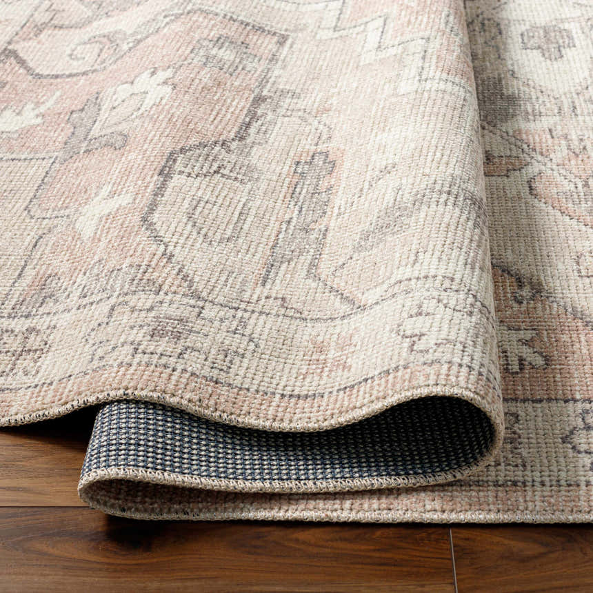 Close-up of the Elle Medallion Taupe Area Rug showing its beige, gray, and pastel red farmhouse pattern and machine-woven texture. Fold