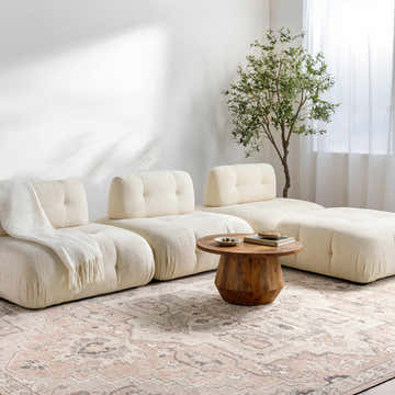 Living room scene with modular sofa and Elle Medallion Taupe Area Rug. Farmhouse style with beige, gray, and light brown tones. Roomscene-Rectangle