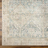 Close-up of Marlene Medallion Beige & Blue Area Rug showing traditional pattern and soft texture on wood floor. Corner