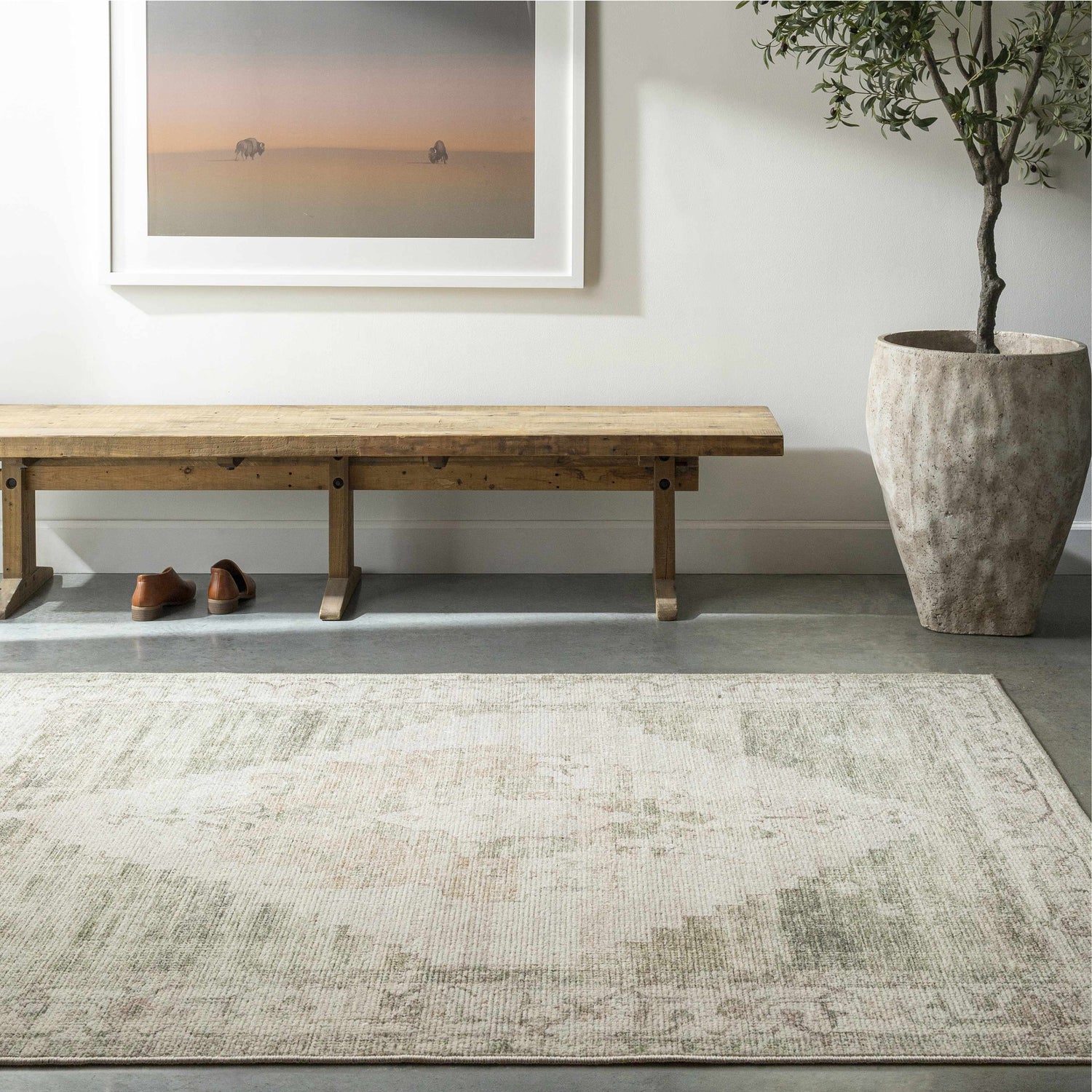 Entryway with a Luca Medallion Olive Area Rug, wooden bench, olive tree in a pot, and artwork featuring bison. Roomscene-Rectangle