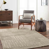 Living room scene with a gray chair, wooden side table, and the Akuji Area Rug in light peach and gray. Roomscene-Rectangle