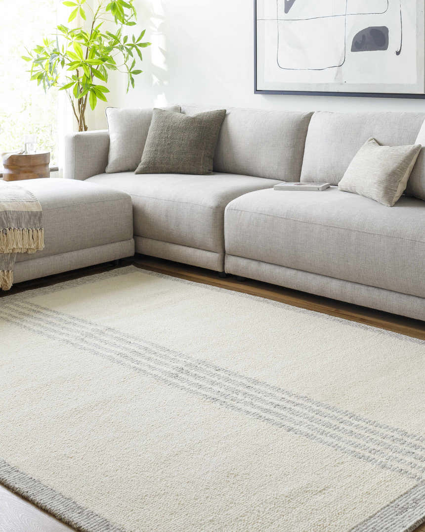 Living room scene with a gray sectional sofa and the Ande Cream Area Rug with gray stripes. Roomscene-Rectangle