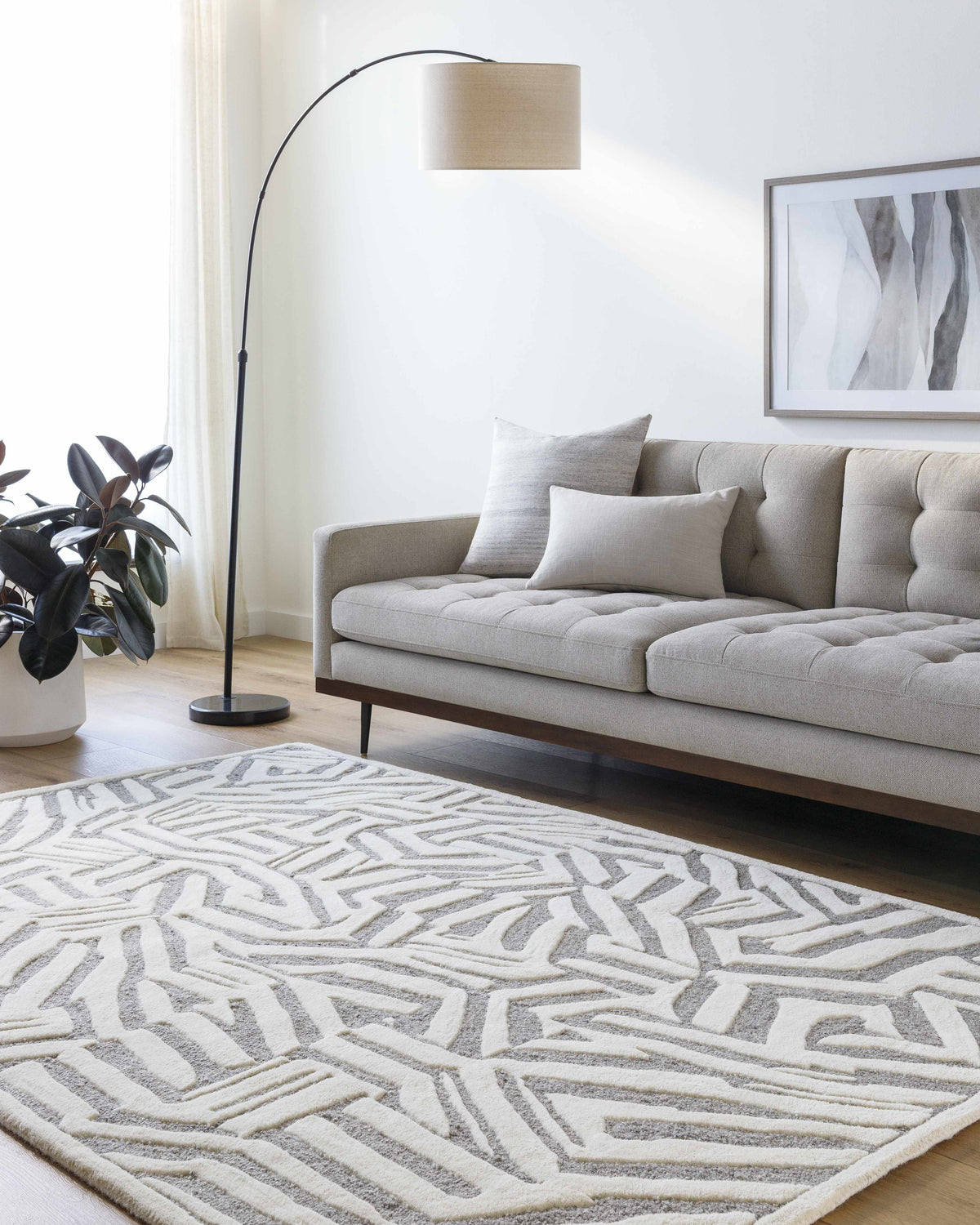 Living room scene with a gray sofa and Avian Gray Wool Area Rug featuring a cream and taupe geometric pattern. Roomscene-Rectangle
