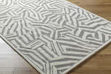 Close-up of the Avian Gray Wool Area Rug. Cream and taupe geometric pattern on a hand-tufted wool rug. Contemporary style. Corner