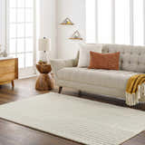 Living room scene with a Whan Off White Area Rug, beige sofa, wood accents, and natural light. Roomscene-Rectangle