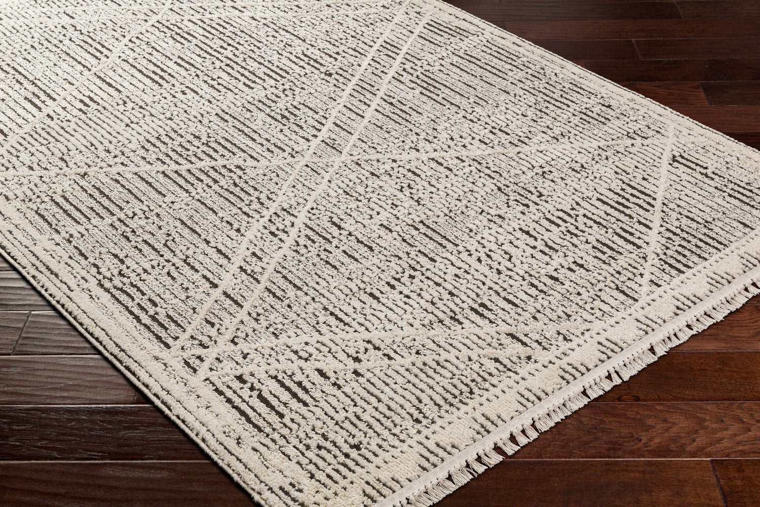 Close-up of the Luuk Area Rug showcasing its ivory and dark brown geometric pattern and soft, textured weave. Corner