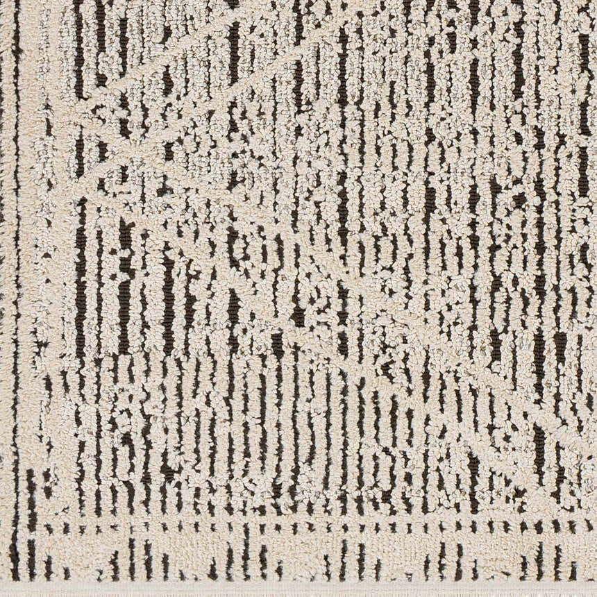 Close-up of Luuk Area Rug. Ivory rug with a dark brown geometric pattern and textured pile. Swatch