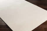 Close-up of the Sabinsville Carpet in cream, showing its subtle striped texture on dark wood flooring. Corner
