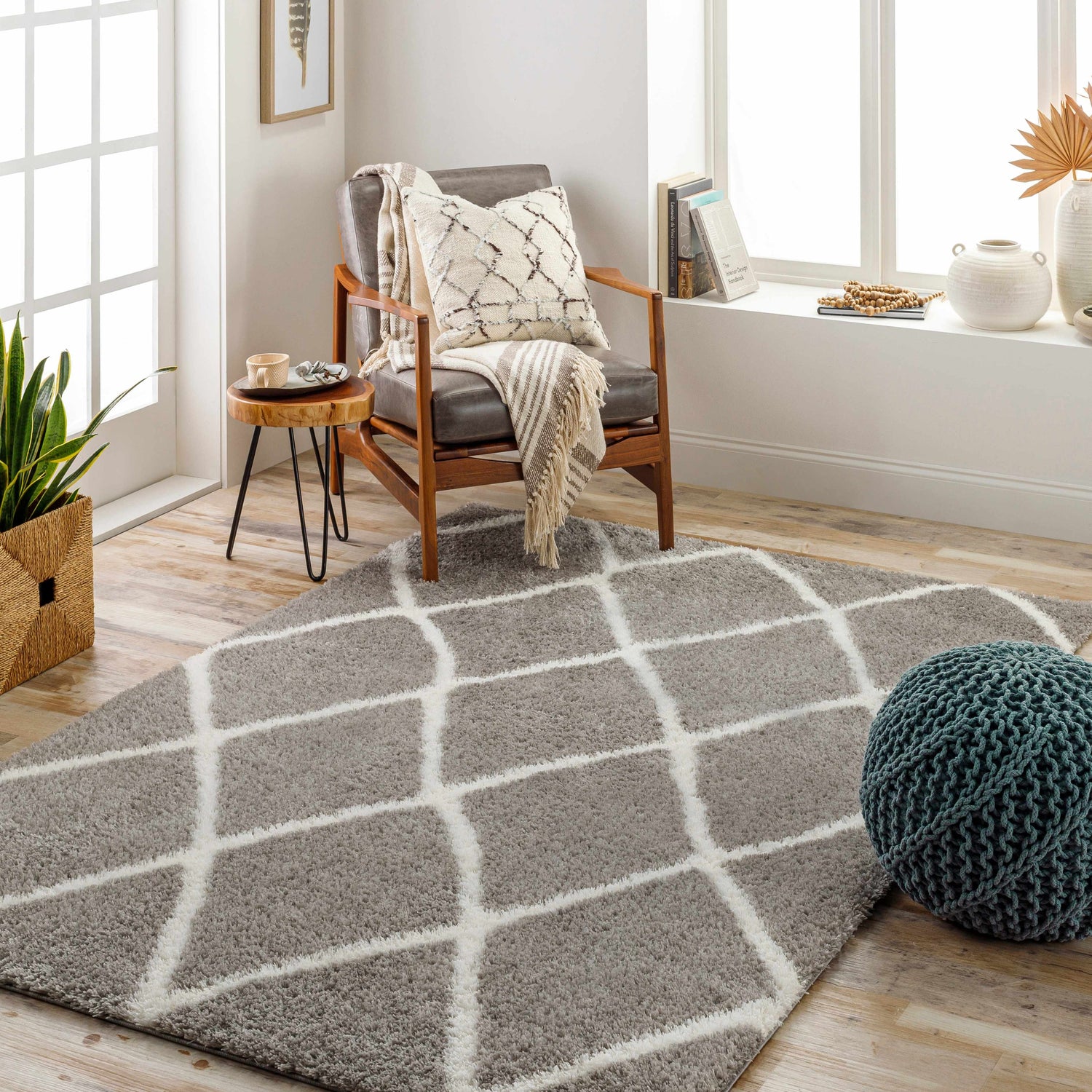 Cozy living room scene with a gray Faye Area Rug featuring a geometric pattern, chair, and boho accents. Roomscene-Rectangle