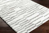 Close-up of the Kuron Area Rug, a shag rug with a contemporary gray and off-white geometric design. Corner