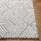 Close-up of the Mura Gray Area Rug showing its geometric shag design and soft texture on a wood floor. Front