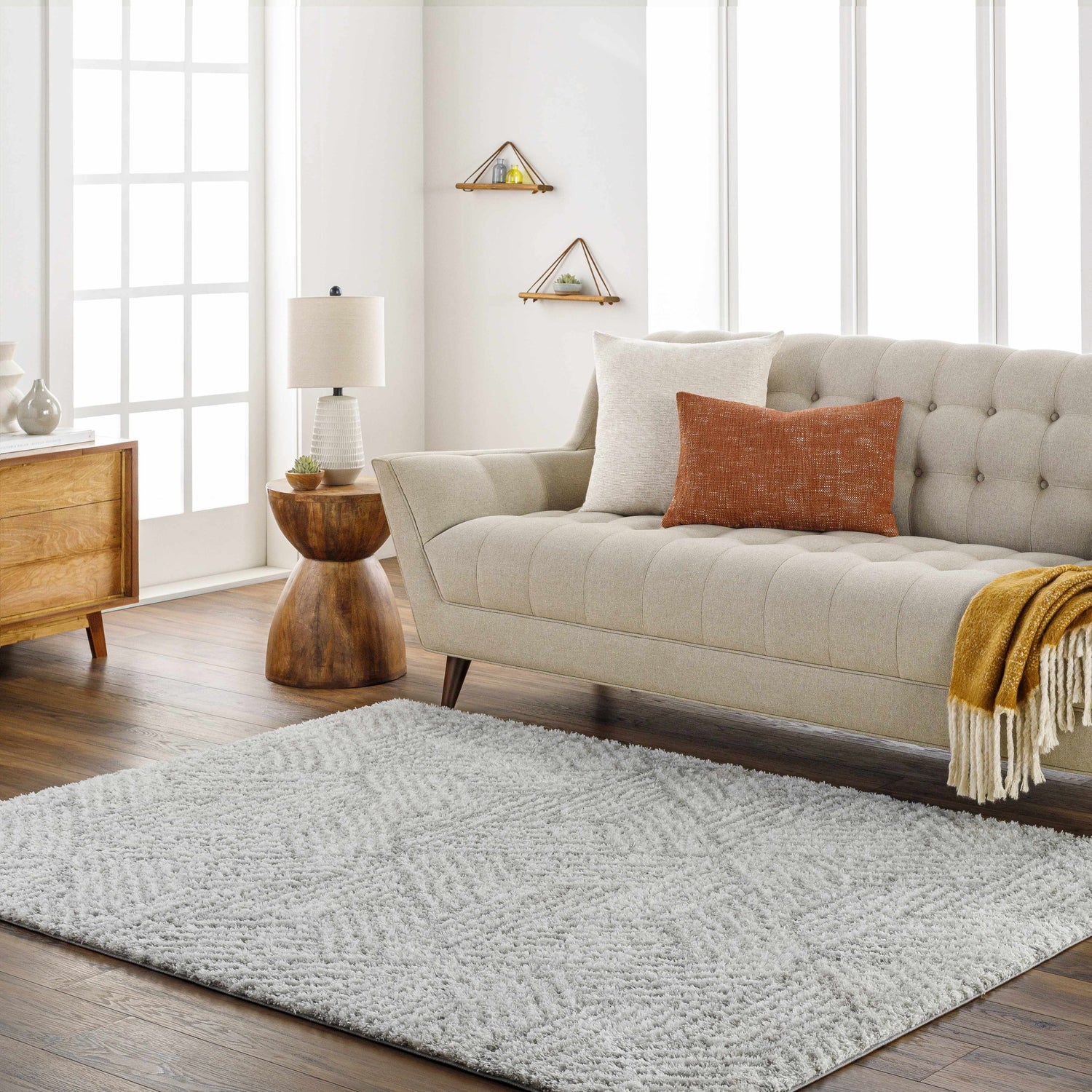 Living room scene with a beige couch and the gray geometric Mura Area Rug on a dark wood floor. Roomscene-Rectangle
