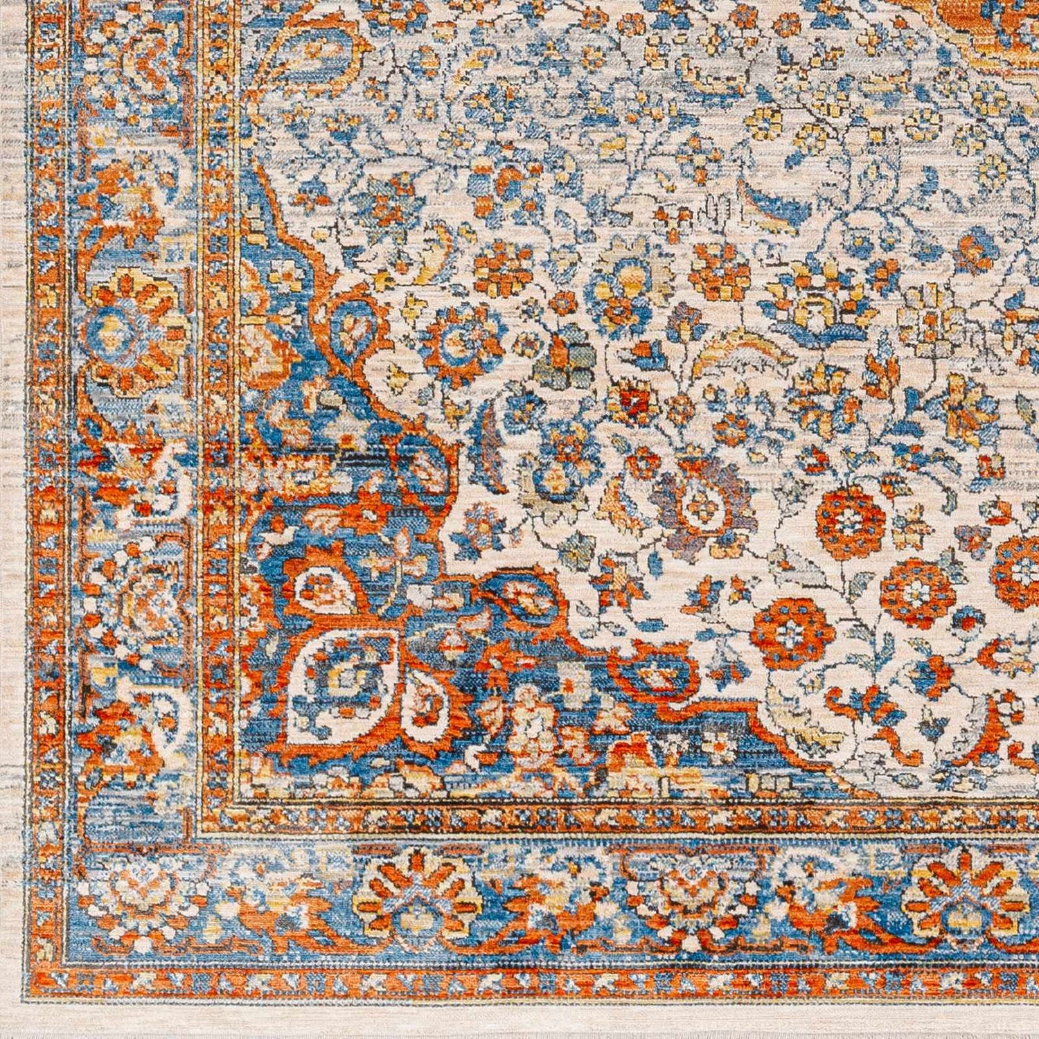 Close-up of the Bojan Area Rug. Traditional floral design in beachhouse, brown, copper, and denim hues. Machine woven texture. Swatch
