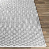 Close-up of the gray and white Scarborough Area Carpet showing its hand woven texture and geometric pattern. Front