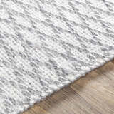 Close up of the hand woven Scarborough Area Carpet in gray and white. Texture