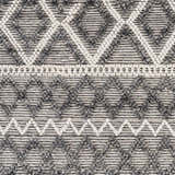 Close-up of the hand-woven Yuka Area Rug. Dark gray and natural gray geometric diamond pattern with textured recycled PET yarn. Swatch