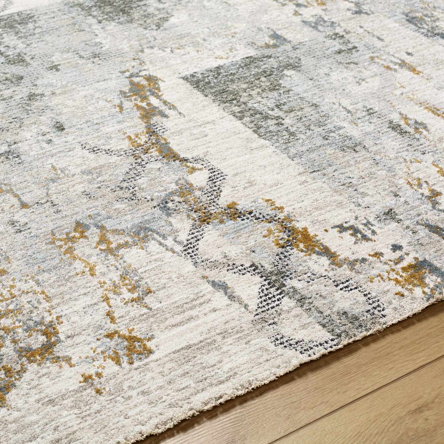 Close-up of the Adlai Textured Rug, showcasing its off-white base with gray, black, and mustard abstract pattern and textured weave. Texture