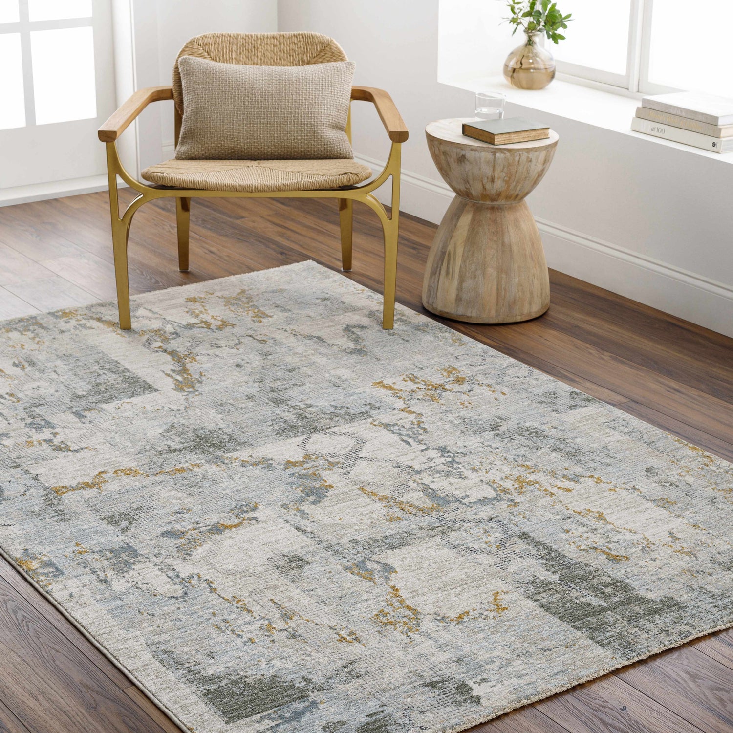 Living room scene with a textured Adlai Rug in dusty sage, ink blue, and mustard colors. Woven chair and wood side table. Roomscene-Rectangle