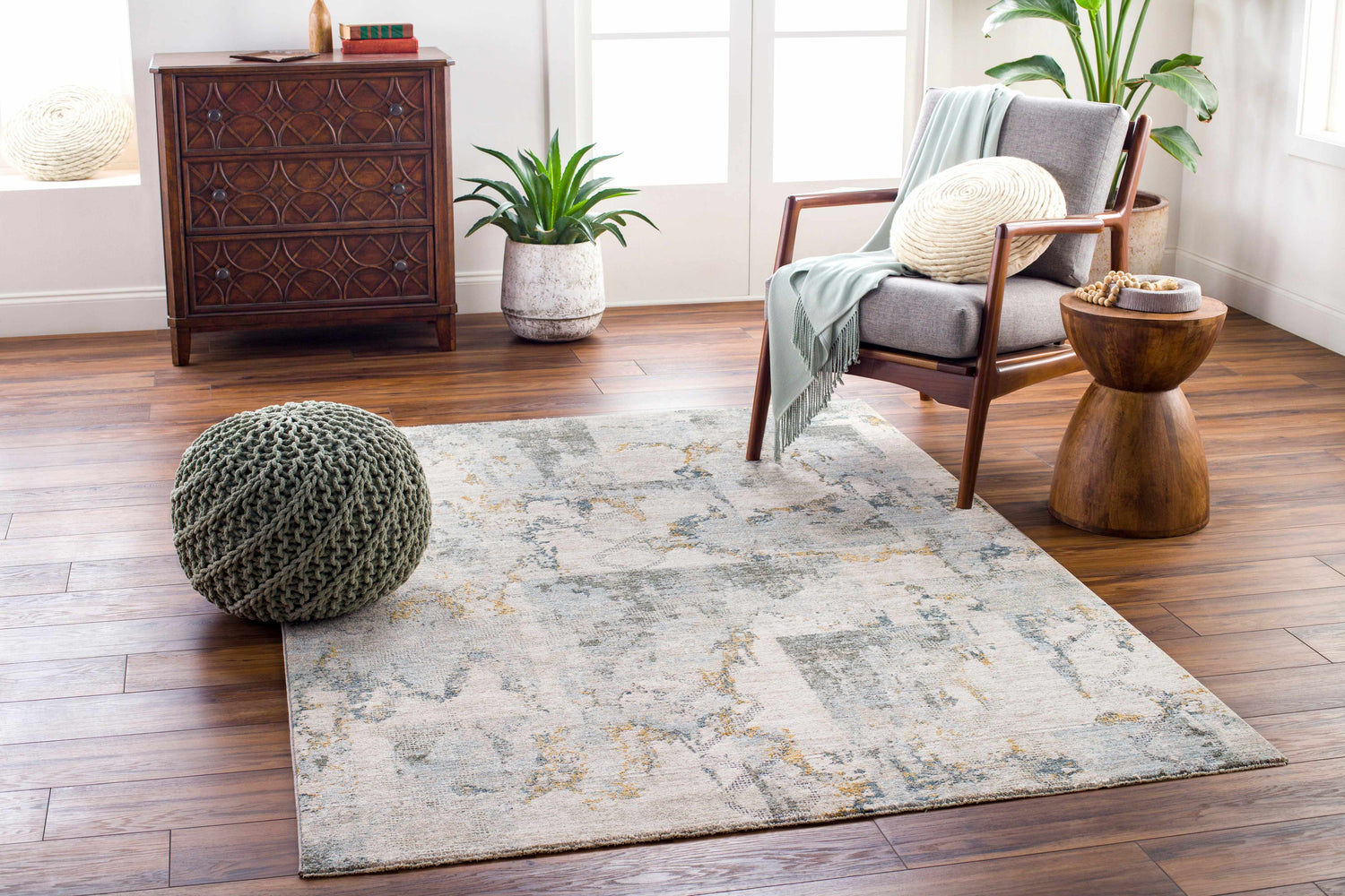 Living room scene with the Adlai Textured Rug in dusty sage, blue, and gold tones. Roomscene-Rectangle