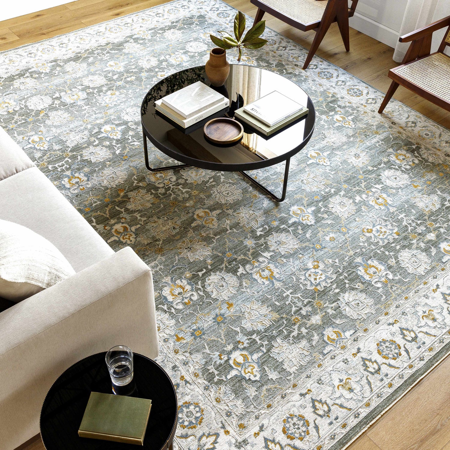 Living room scene with Amaru Green Textured Rug, sofa, round tables, and wood chairs. Roomscene-Rectangle