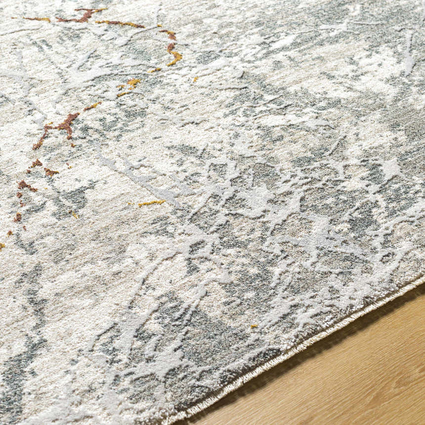 Close up of the Asena Textured Rug with Fringes. Features caramel, gray, and brown abstract pattern. Texture