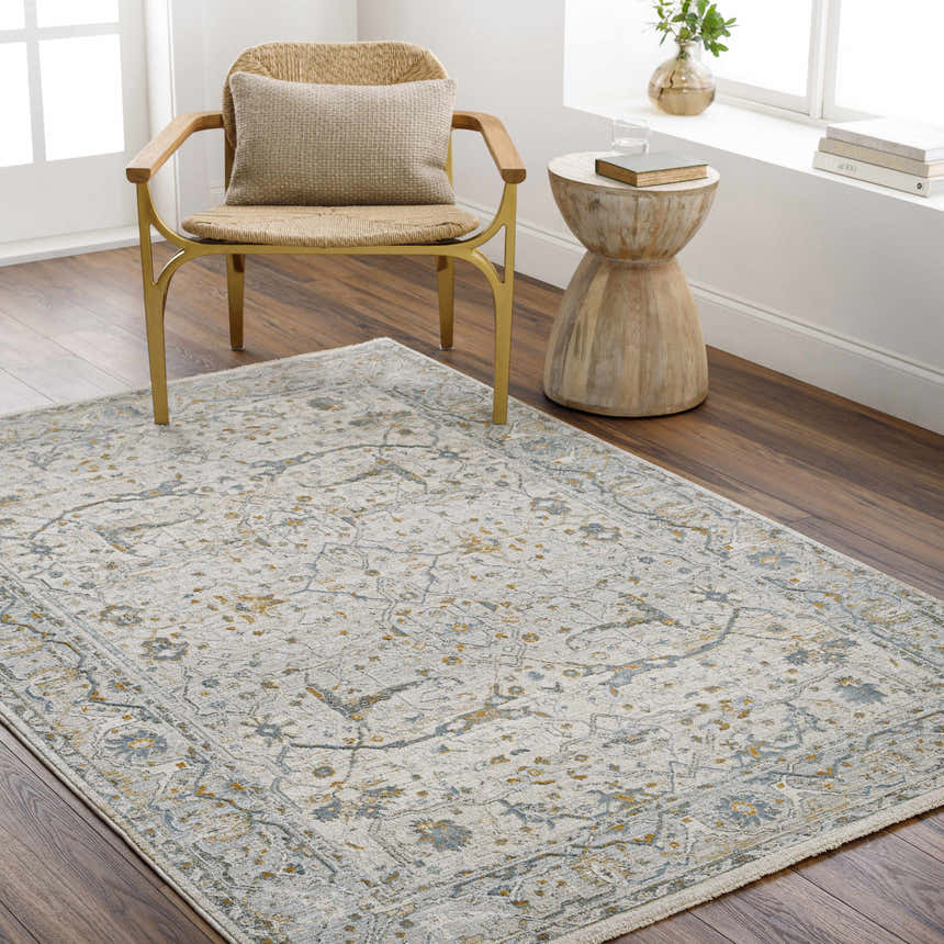 Living room scene with Aviva Off-White Textured Rug, gold chair, and wood side table. Neutral tones and bright natural light. Roomscene-Rectangle
