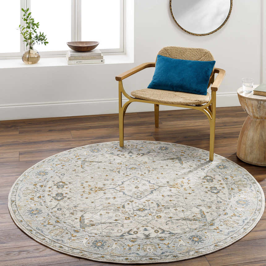Living room scene with a round Aviva Off-White Textured Rug, woven chair, and wood accents. Warm, inviting, and stylish. Roomscene-Round