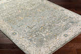 Close-up of Aviva Teal Textured Rug showing its traditional pattern, teal, gray, and mustard colors, and textured weave. Corner