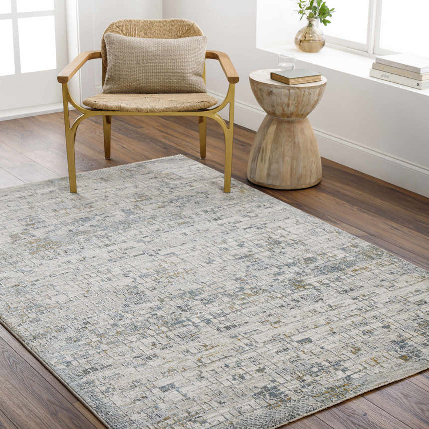 Living room scene with a Chaka Textured Rug in light gray, blue, and mustard tones. Chair and side table. Roomscene-Rectangle