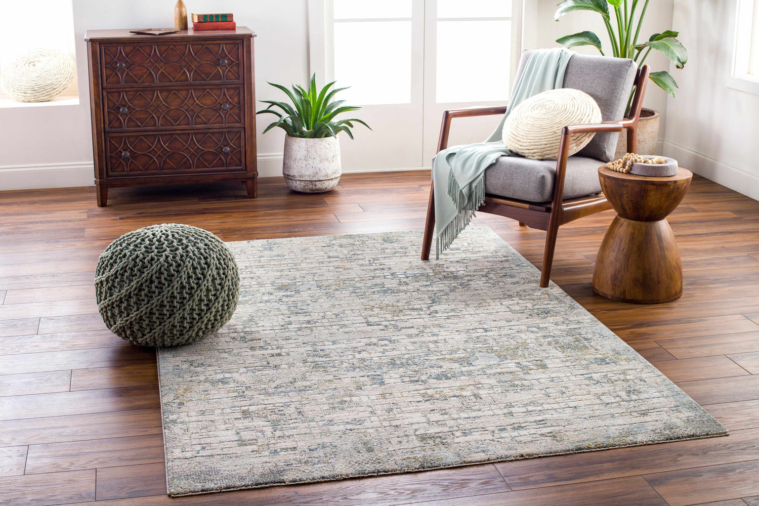 Living room scene with a Chaka Textured Rug in light gray and blue tones, styled with a mid-century modern chair. Roomscene-Rectangle
