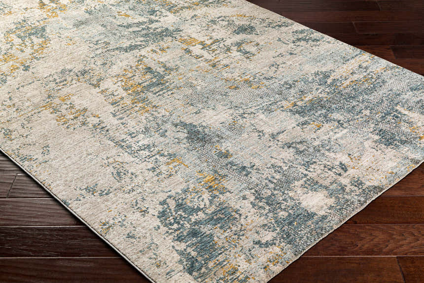 Close-up of the Chaya Textured Abstract Rug. Features dusty sage, ink blue, mustard, and off-white hues. Contemporary style. Corner