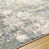 Close-up of the Chaya Textured Abstract Rug. Features dusty sage, ink blue, light gray, and mustard colors. Texture
