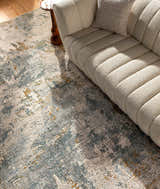 Living room scene with a Chaya Textured Abstract Rug in dusty sage, ink blue, and mustard under a cream boucle sofa. Styleshot