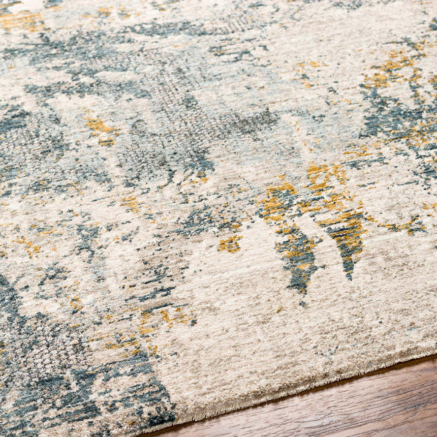 Close-up of the Chaya Textured Abstract Rug. Features dusty sage, ink blue, mustard, and off-white hues. Texture