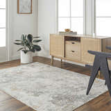 Living room scene with a gray Edana Textured Rug, wood floors, and a light wood console table. Roomscene-Rectangle