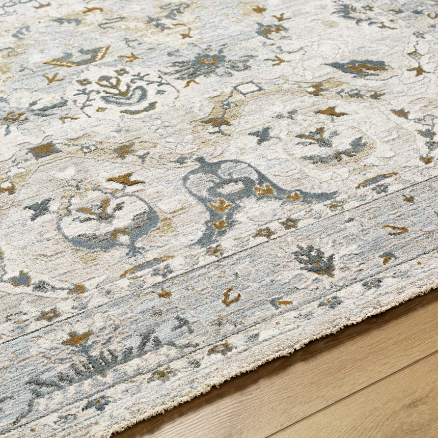 Close-up of the Emile Textured Rug. Features a traditional design in off-white, light gray, and mustard tones. Texture