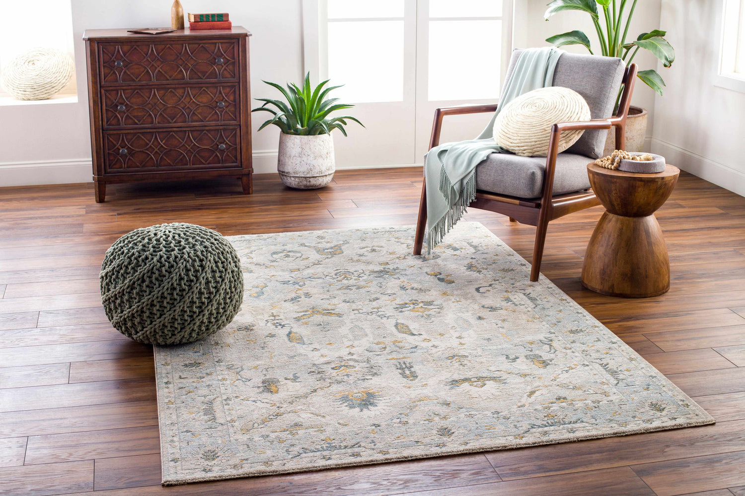Living room scene with a gray chair, wood accents, and the Emile Textured Rug in dusty sage and light gray. Roomscene-Rectangle