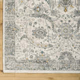 Close up of Gauge Cream & Gray Blue Rug showing traditional floral pattern and soft texture. Corner