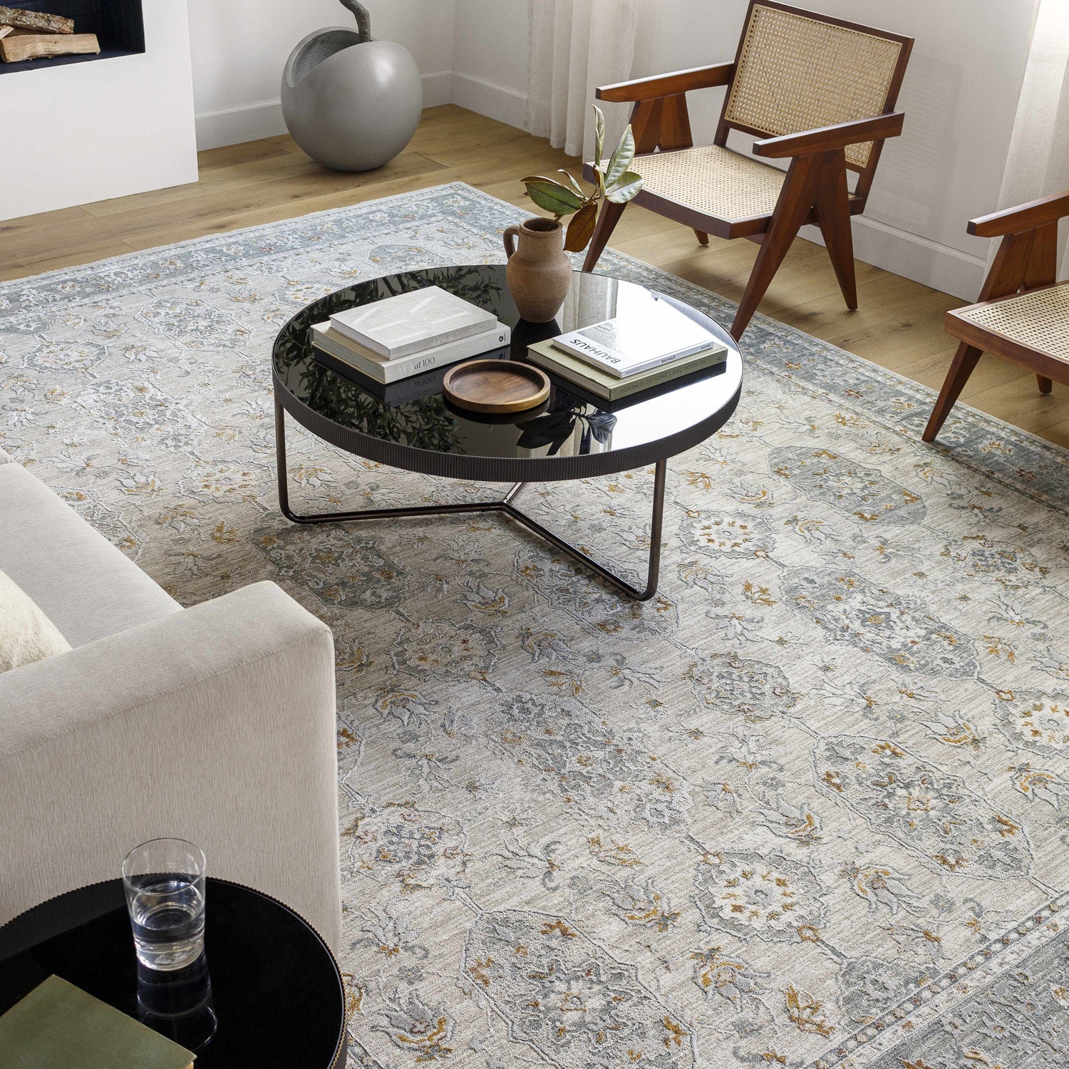 Living room with a gray sofa and Greco Textured Rug with Fringes in gray, brown, and natural tones. Roomscene-Rectangle
