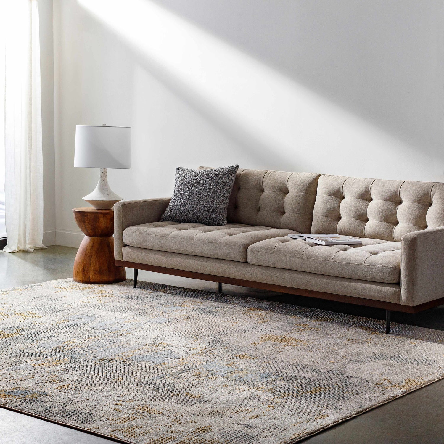Living room scene with a Gryta Textured Rug, beige sofa, wood side table, and natural light. Roomscene-Rectangle